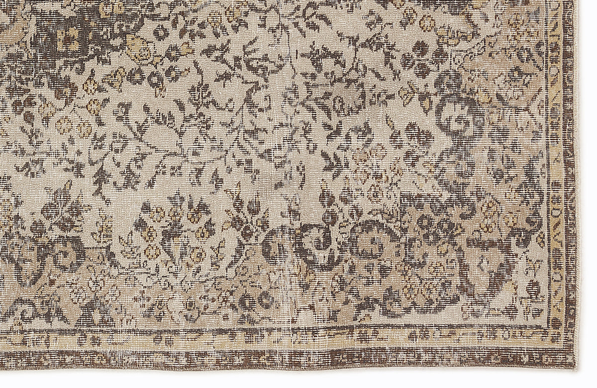Beige and dark brown rug with a distressed, traditional floral pattern and a bordered edge.