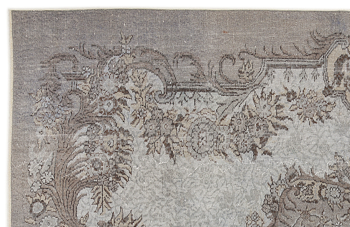 Grey and brown vintage-style rug with a distressed floral medallion pattern on a white background.