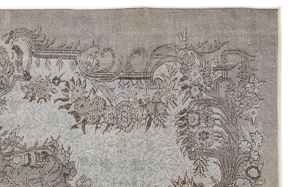 Grey and brown distressed rug with a traditional floral medallion pattern on a white background.