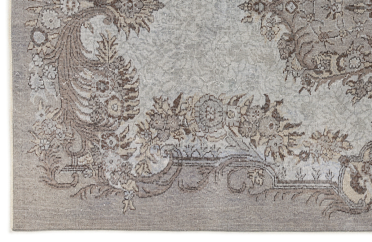 Grey and brown rug with a distressed traditional floral medallion pattern.