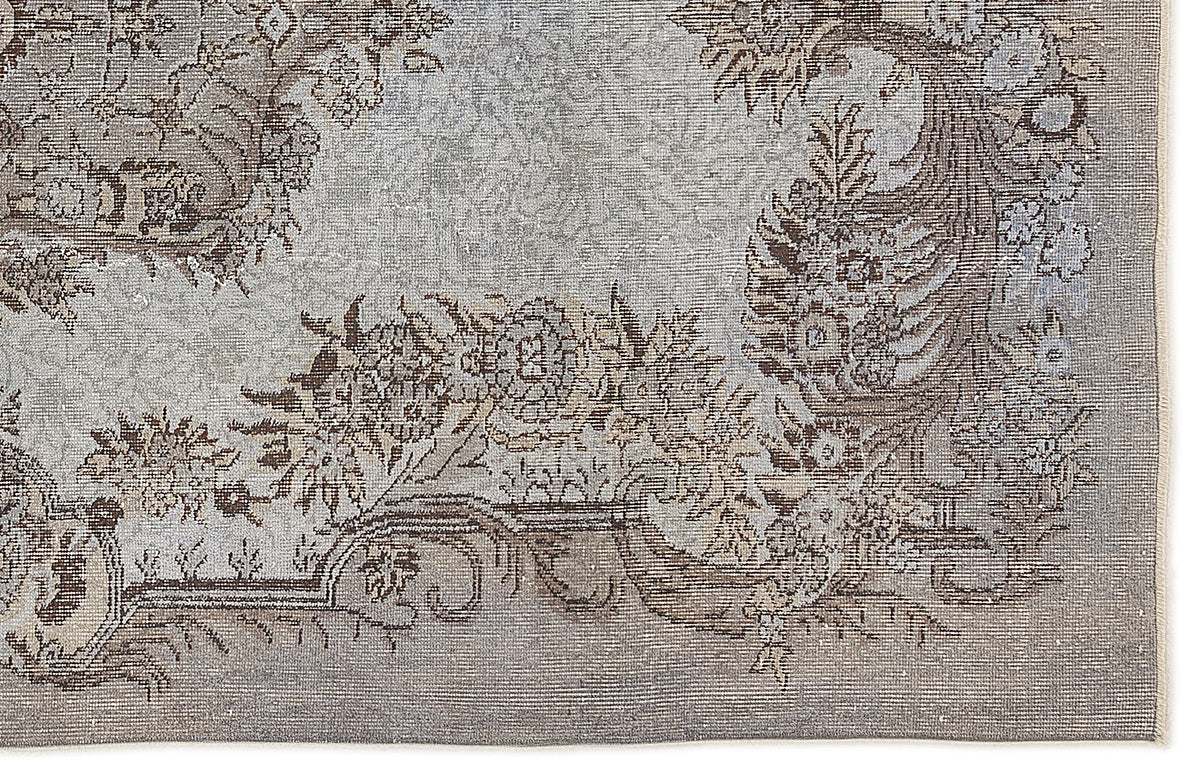 Grey and brown traditional rug with a distressed floral medallion pattern on a white background.