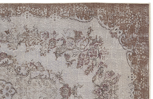 Load image 1 in gallery view. Brown and light grey distressed rug with a traditional floral medallion pattern.