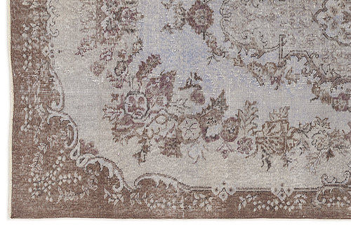 Load image 1 in gallery view. Distressed brown and light blue rug with a traditional floral medallion pattern and ornate border.