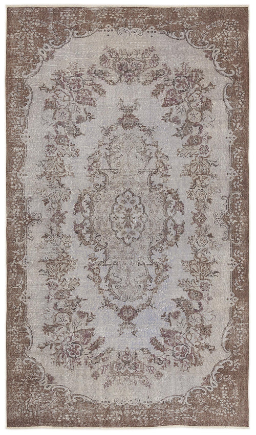 Load image 1 in gallery view. Brown and light grey distressed rug with a central floral medallion and ornate border pattern.