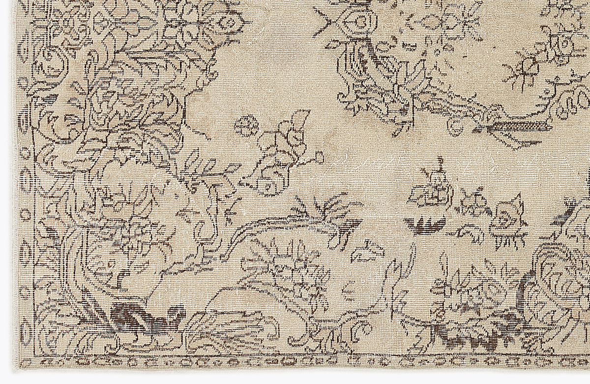 Beige rug with a dark brown distressed floral and vine pattern.
