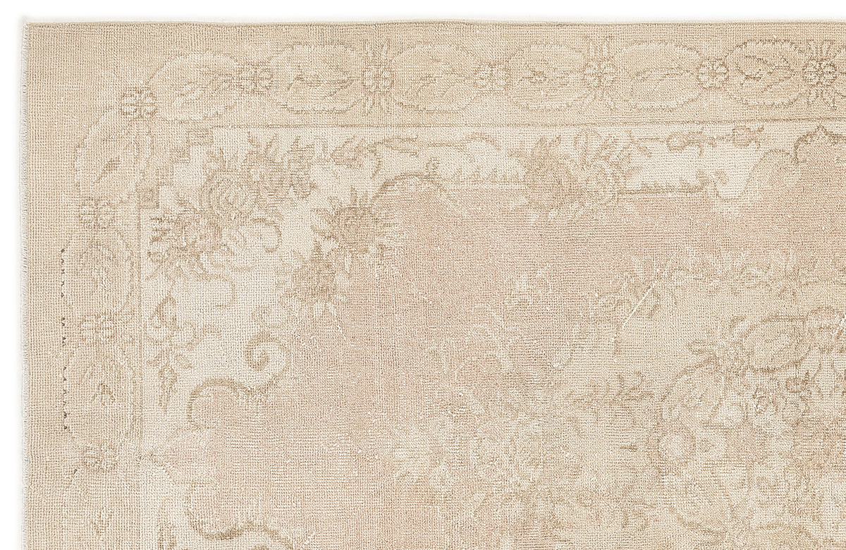 Beige monochromatic rug with a traditional floral border and central medallion pattern on a white background.