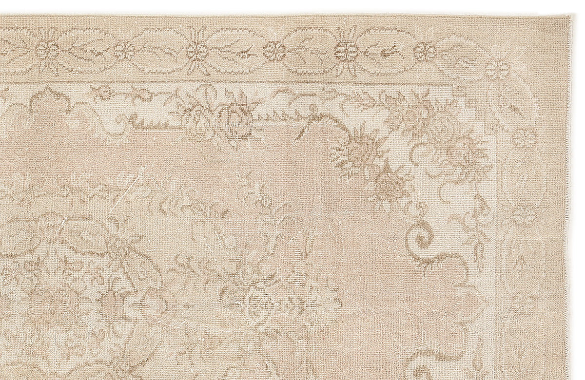 Beige and cream traditional rug with a distressed floral medallion pattern and a decorative border.
