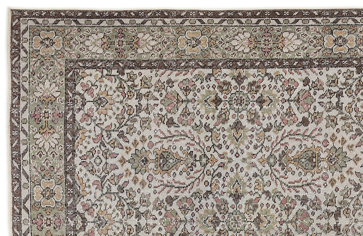 Traditional rug with a cream background, dark brown border, and intricate floral medallion pattern in sage and dusty pink.