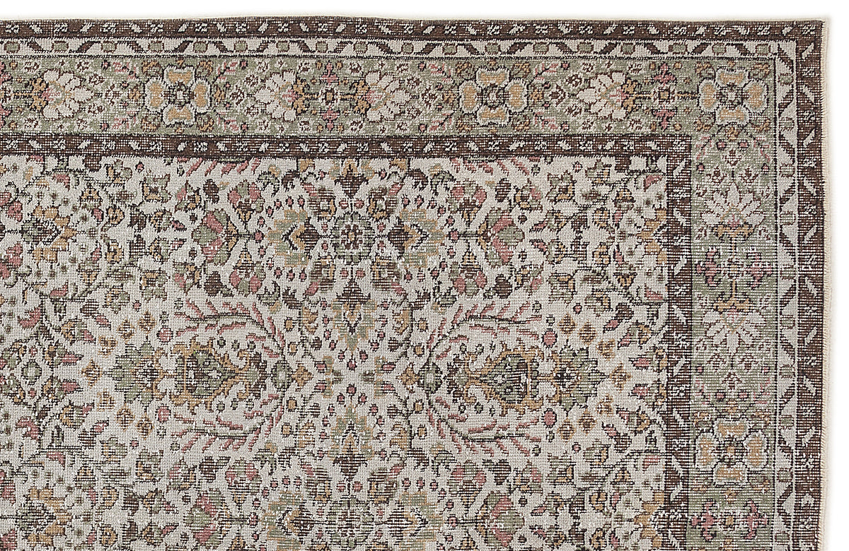 Traditional Persian-style rug with a floral medallion pattern in muted brown, sage green, and pink on a cream background.