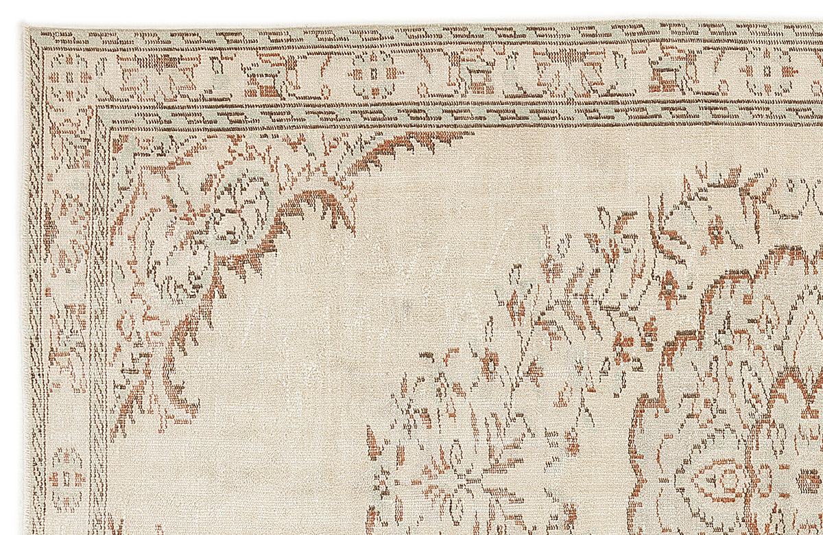 Cream and beige rug with a distressed traditional floral border and medallion pattern.