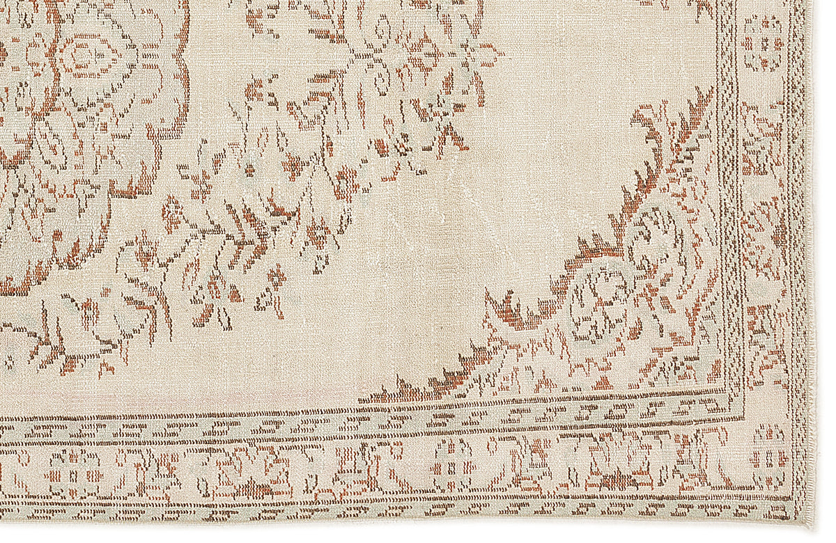 Cream and terracotta rug with a distressed traditional floral medallion pattern and a detailed border.