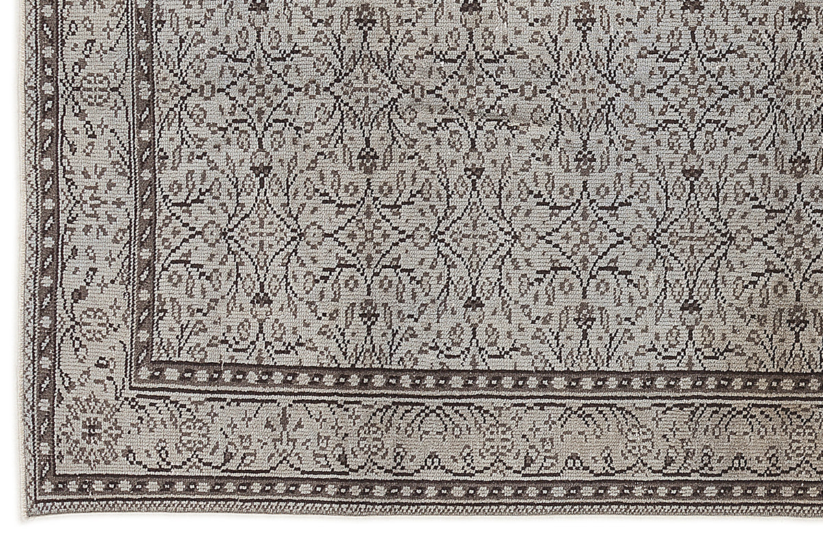 Grey and charcoal rug with a traditional floral medallion pattern and a detailed geometric border.