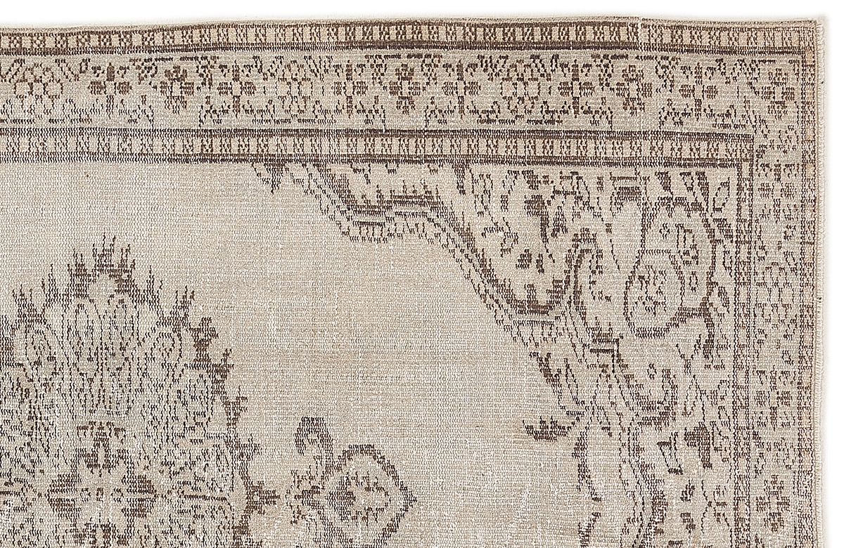 Beige and brown rug with a distressed traditional medallion pattern and a detailed geometric border.