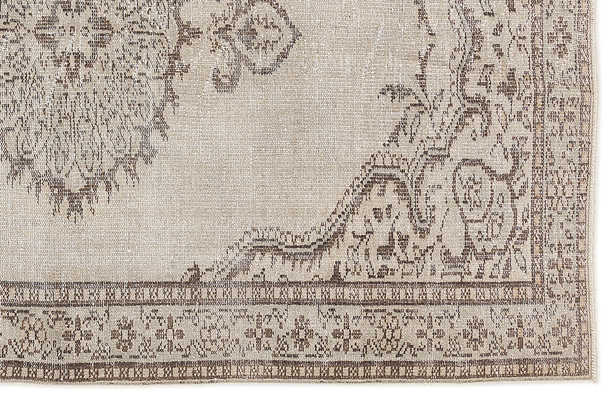 Beige and brown distressed rug with a traditional floral medallion pattern and a detailed border.