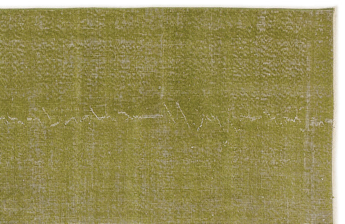 Load image 1 in gallery view. Olive green rug with a distressed, textured finish and subtle white linear detailing.