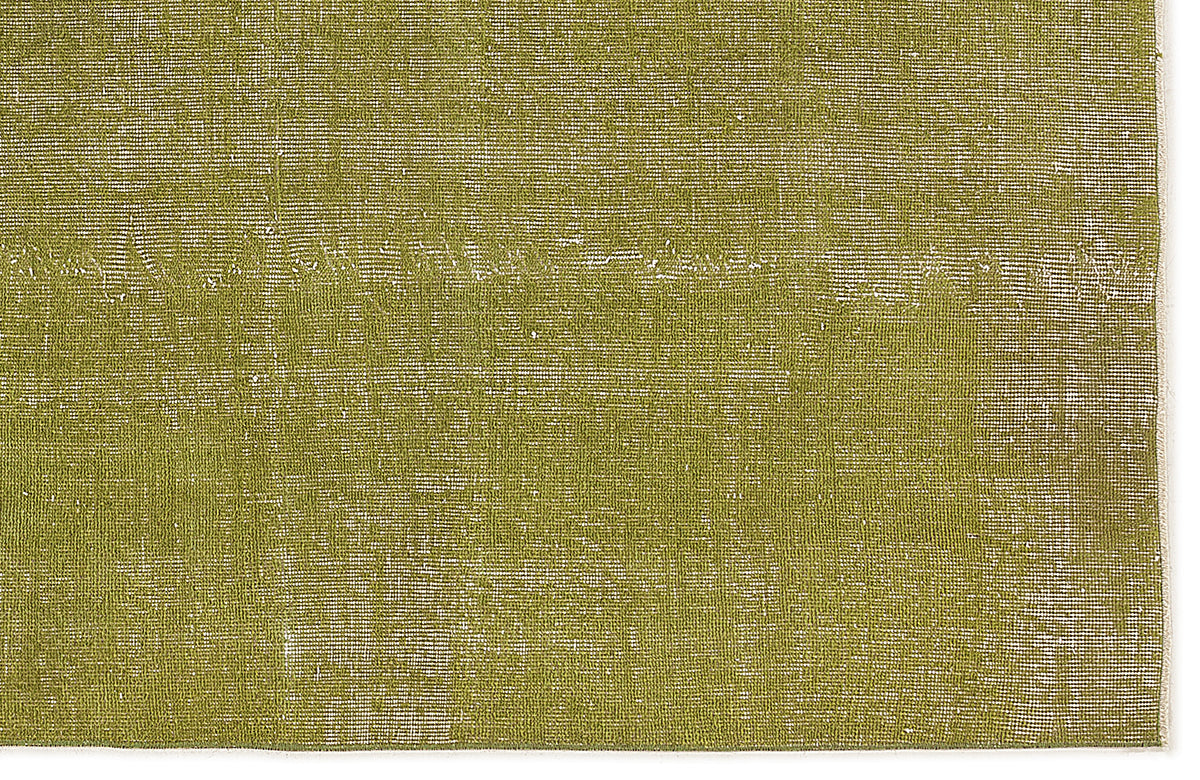 Olive green rug with a distressed, weathered texture and visible white woven base.