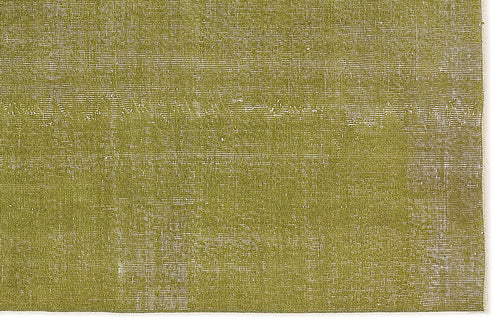 Load image 1 in gallery view. Olive green rug with a distressed, weathered texture and visible white woven base.