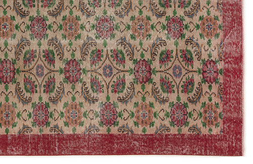 Load image 1 in gallery view. Beige rug with a repeating floral medallion pattern in red, green, and blue, featuring a wide red border.