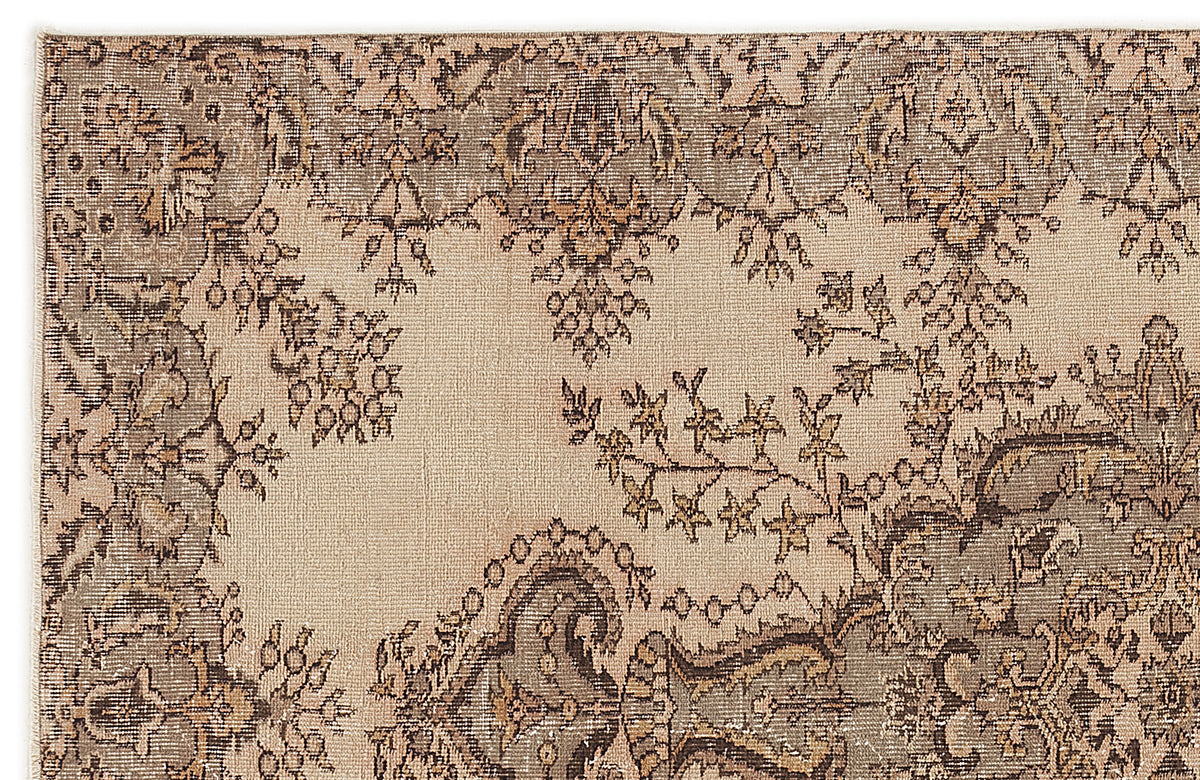 Beige and taupe rug with a distressed traditional floral medallion pattern.