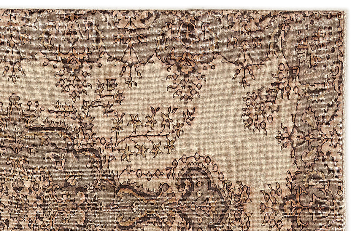 Beige and taupe vintage-style rug with a distressed floral medallion pattern.