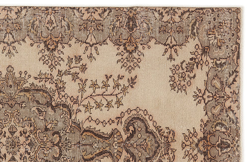 Load image 1 in gallery view. Beige and taupe vintage-style rug with a distressed floral medallion pattern.