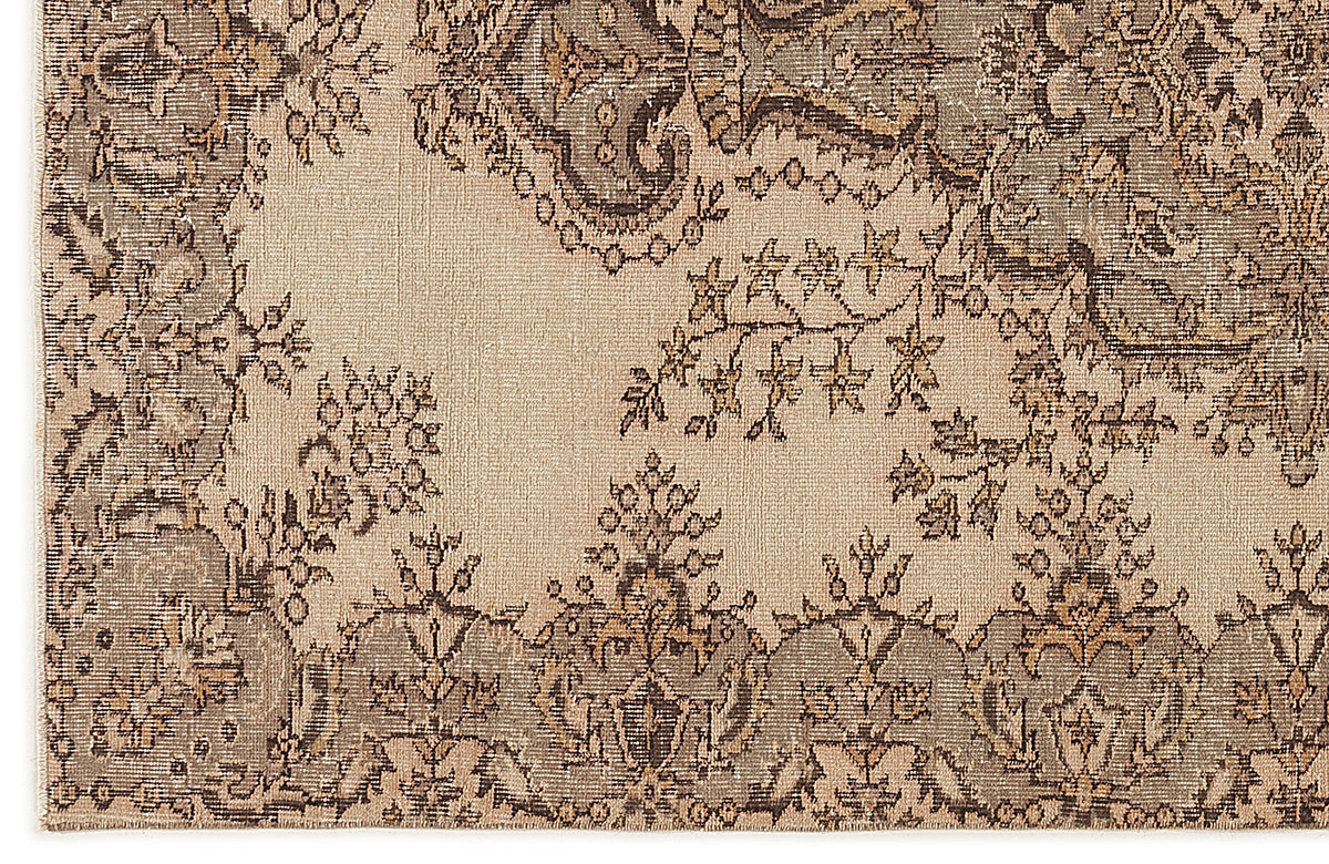 Beige and grey traditional rug with a distressed floral medallion pattern and intricate border detail.