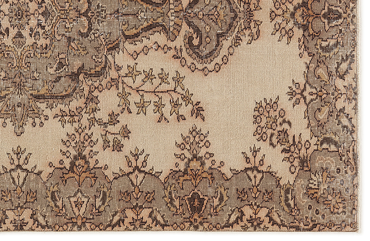 Beige rug with a distressed, dark brown and tan traditional floral medallion pattern.