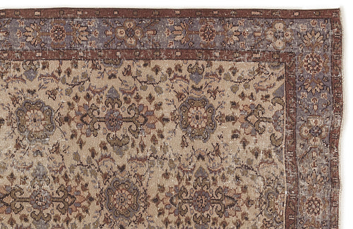 Load image 1 in gallery view. Distressed beige rug with a brown and slate blue floral medallion pattern and a wide decorative border.