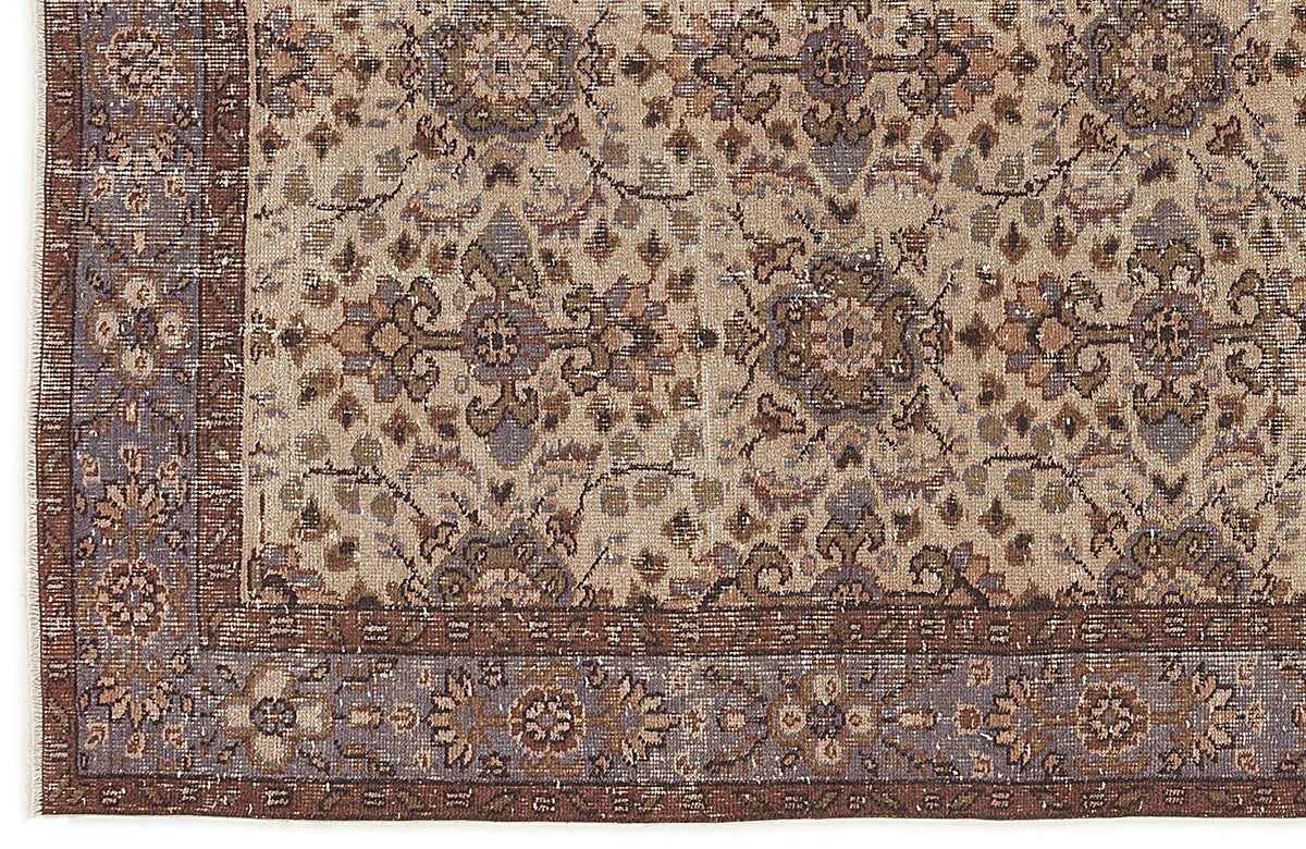 Beige, brown, and slate blue traditional rug with a distressed floral medallion pattern and a detailed border.
