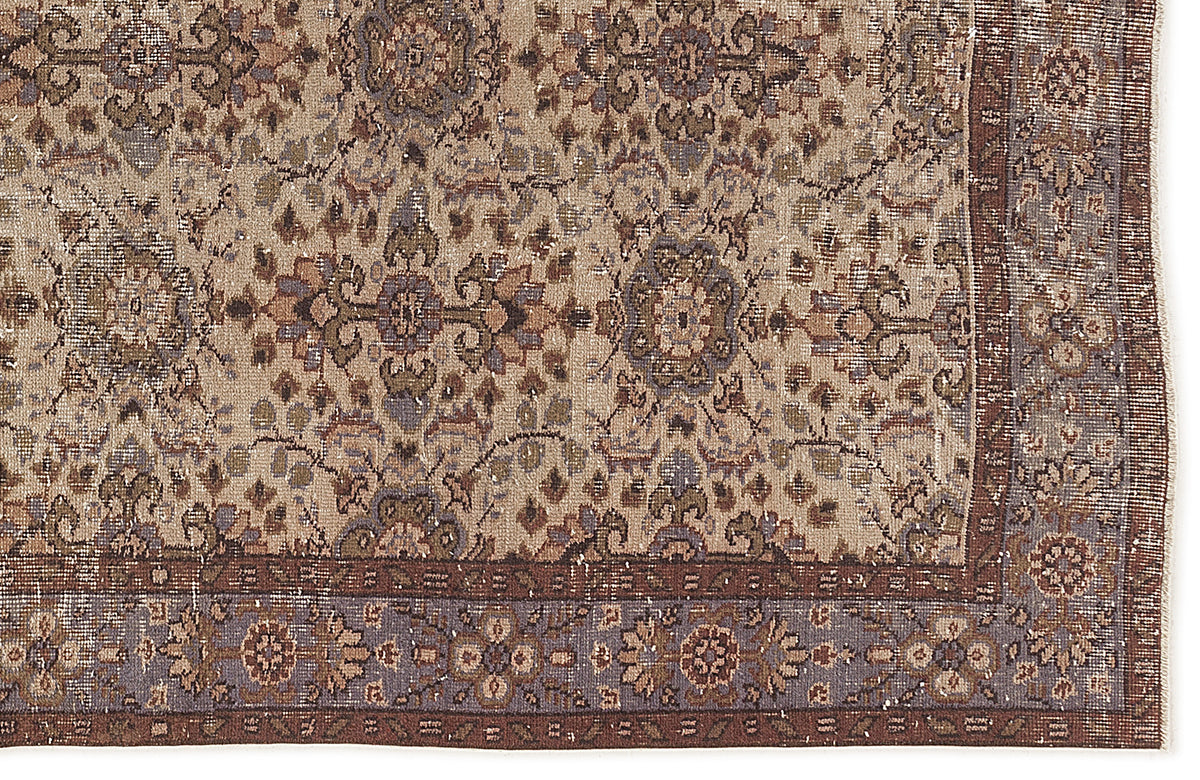 Distressed beige, brown, and muted blue traditional rug with a repeating floral medallion pattern and a wide border.
