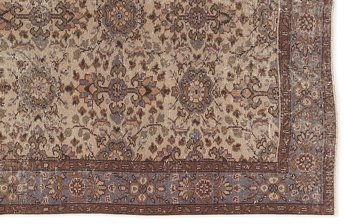 Load image 1 in gallery view. Distressed beige, brown, and muted blue traditional rug with a repeating floral medallion pattern and a wide border.