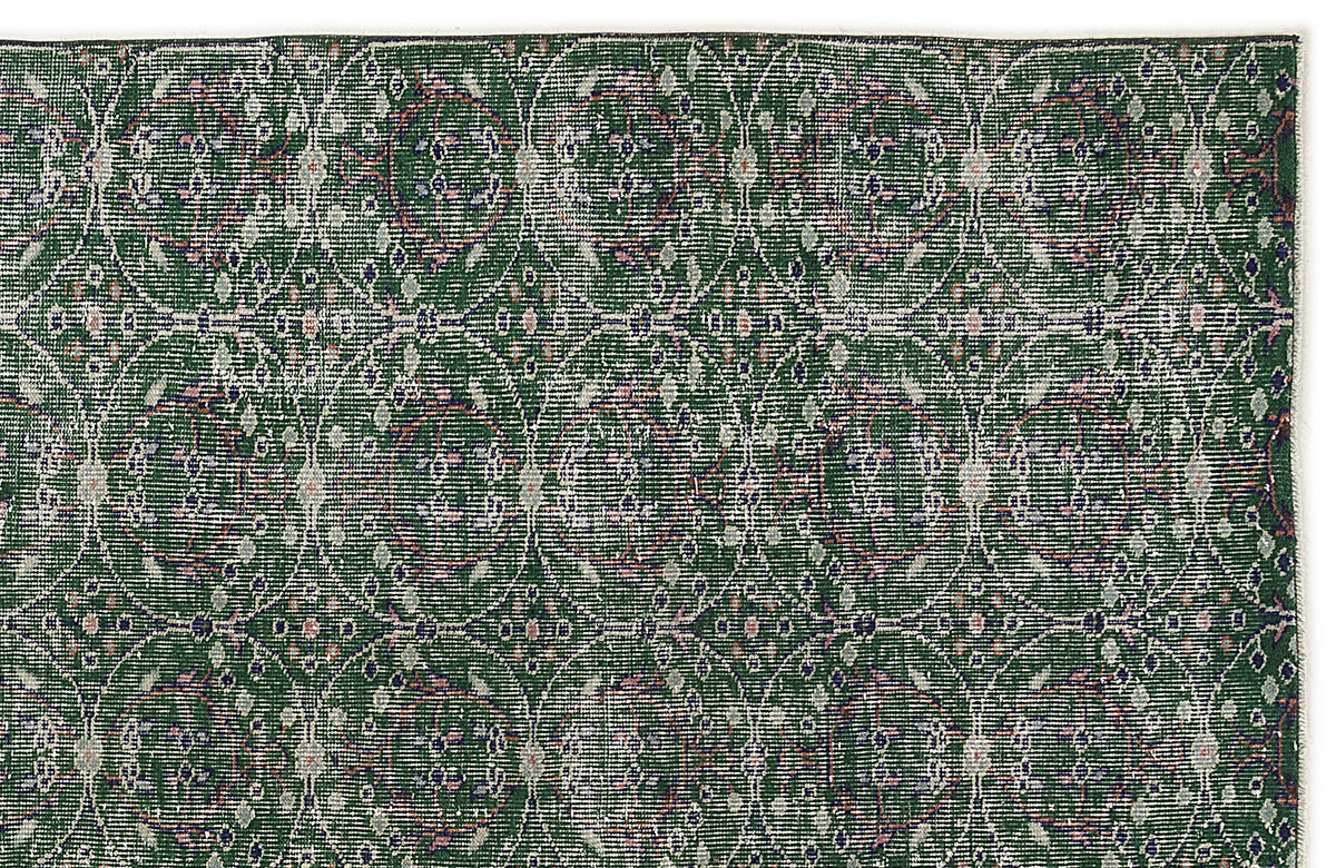 Forest green rug with a repeating white circular lattice pattern and small floral accents on a white background.