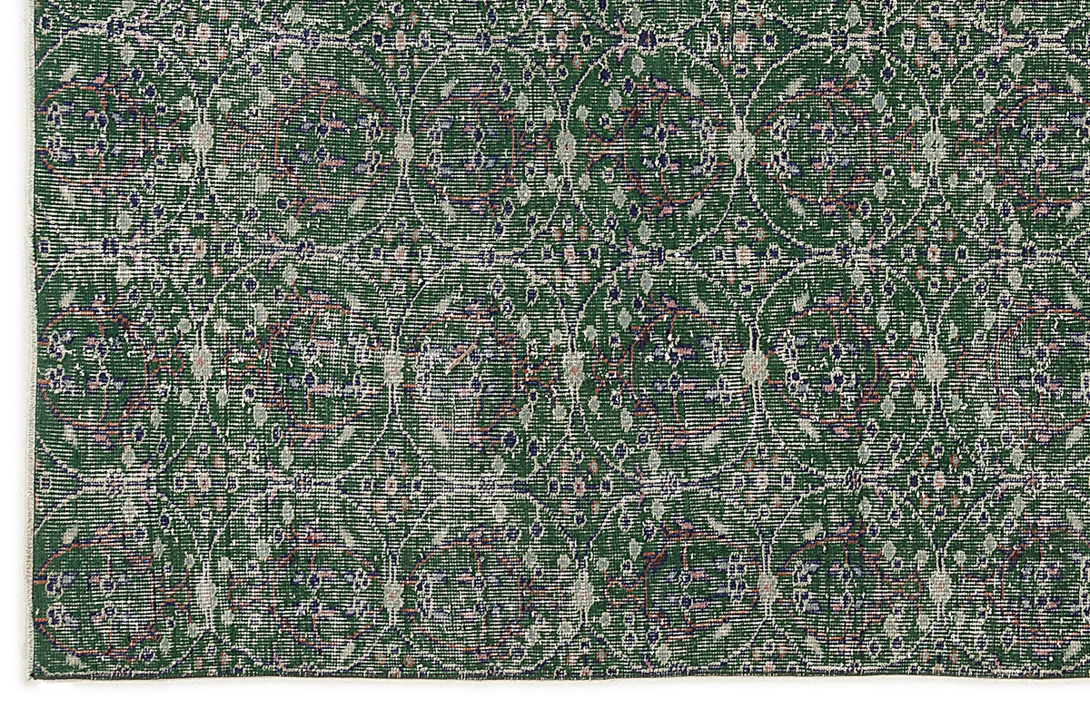 Forest green rug with a repeating white circular lattice pattern and distressed floral accents.