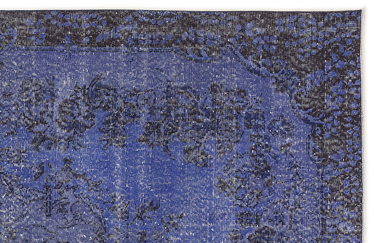 Deep blue and black distressed rug with a traditional floral medallion pattern on a white background.