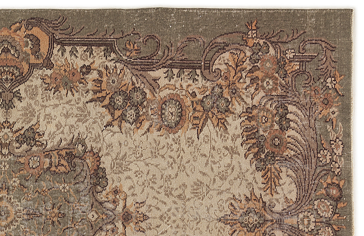 Olive green and beige rug with a distressed traditional floral border and intricate central medallion pattern.
