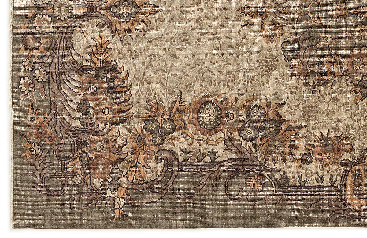 Sage green and tan traditional rug with a distressed floral medallion pattern and ornate border.