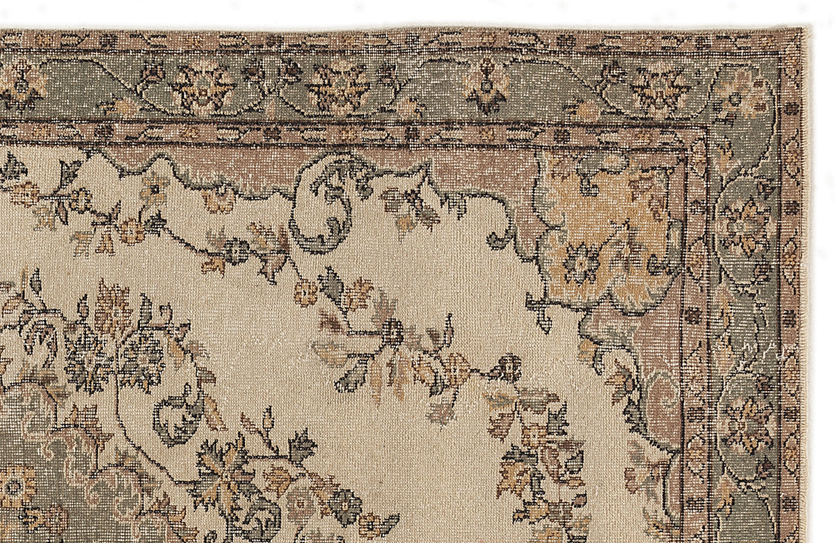 Beige, sage green, and tan traditional rug with a distressed floral medallion pattern on a white background.