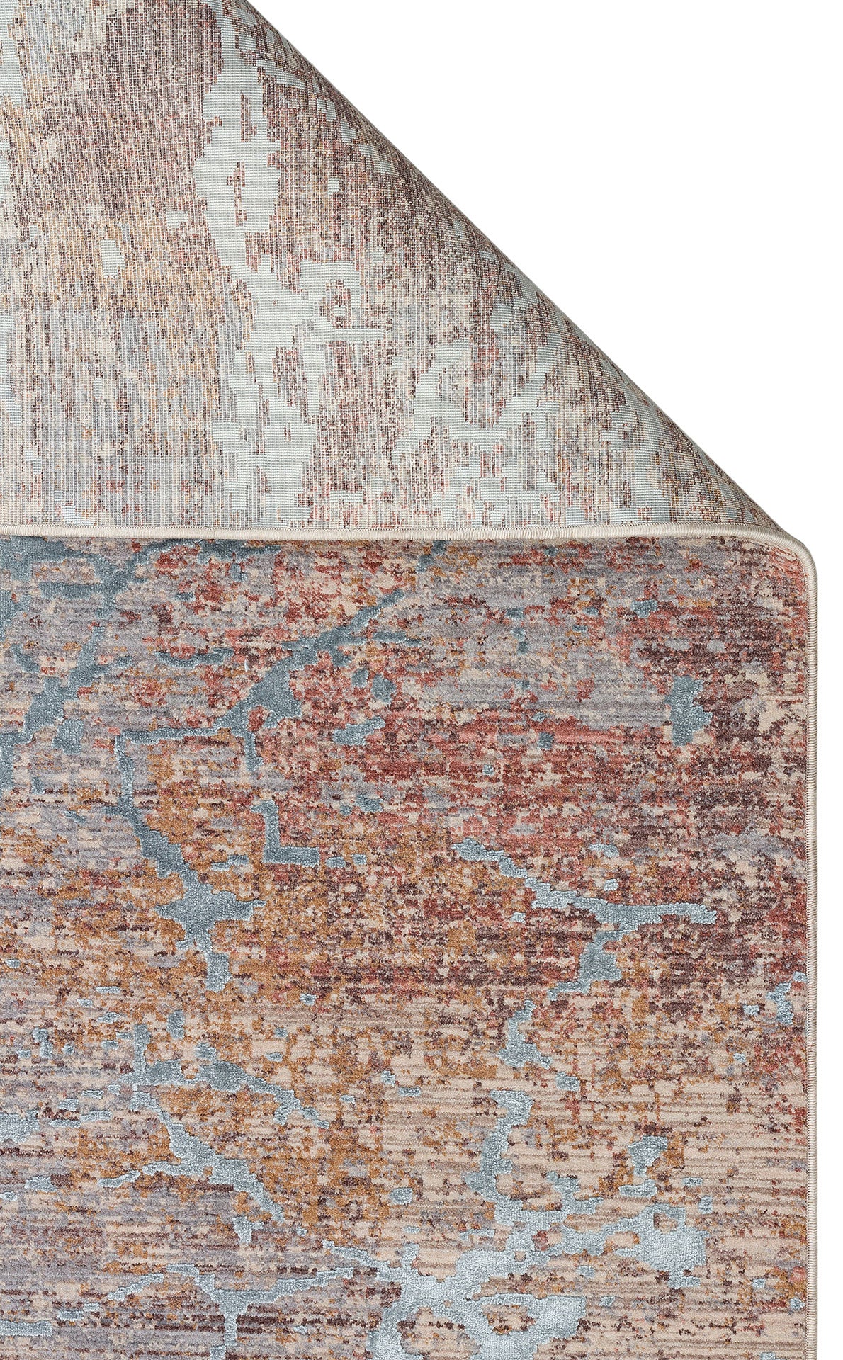 Distressed abstract rug in rust, grey, and beige with a folded corner revealing the woven backing.