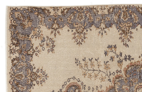 Load image 1 in gallery view. Beige rug with a distressed grey and brown floral medallion border and scattered botanical motifs.