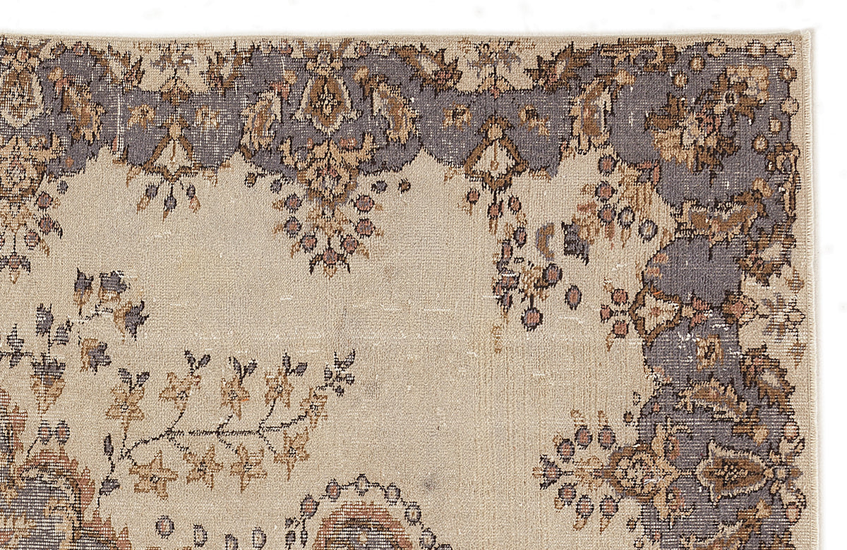 Beige rug with a distressed floral border in slate blue and brown on a white background.
