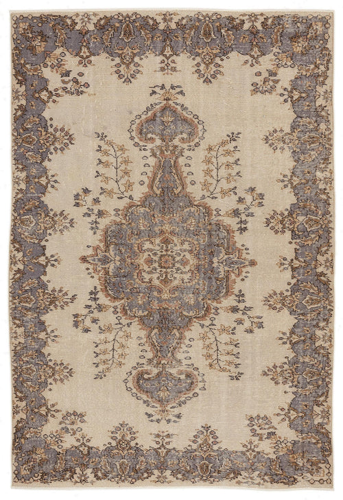 Load image 1 in gallery view. Beige rug with a central grey and brown floral medallion and a matching ornate border in a distressed vintage style.