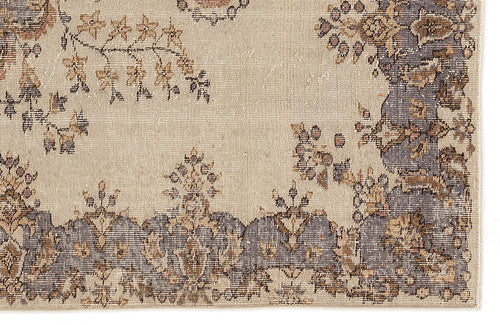 Load image 1 in gallery view. Beige rug with a distressed floral medallion pattern in charcoal, tan, and muted brown tones.