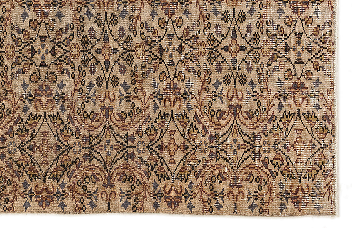 Tan rug with a repeating black, brown, and muted blue floral damask pattern in a diamond grid layout.