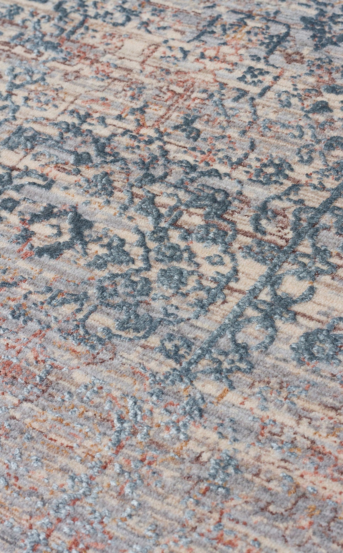 Beige, blue, and rust-colored distressed rug with a faded traditional medallion pattern and textured pile.