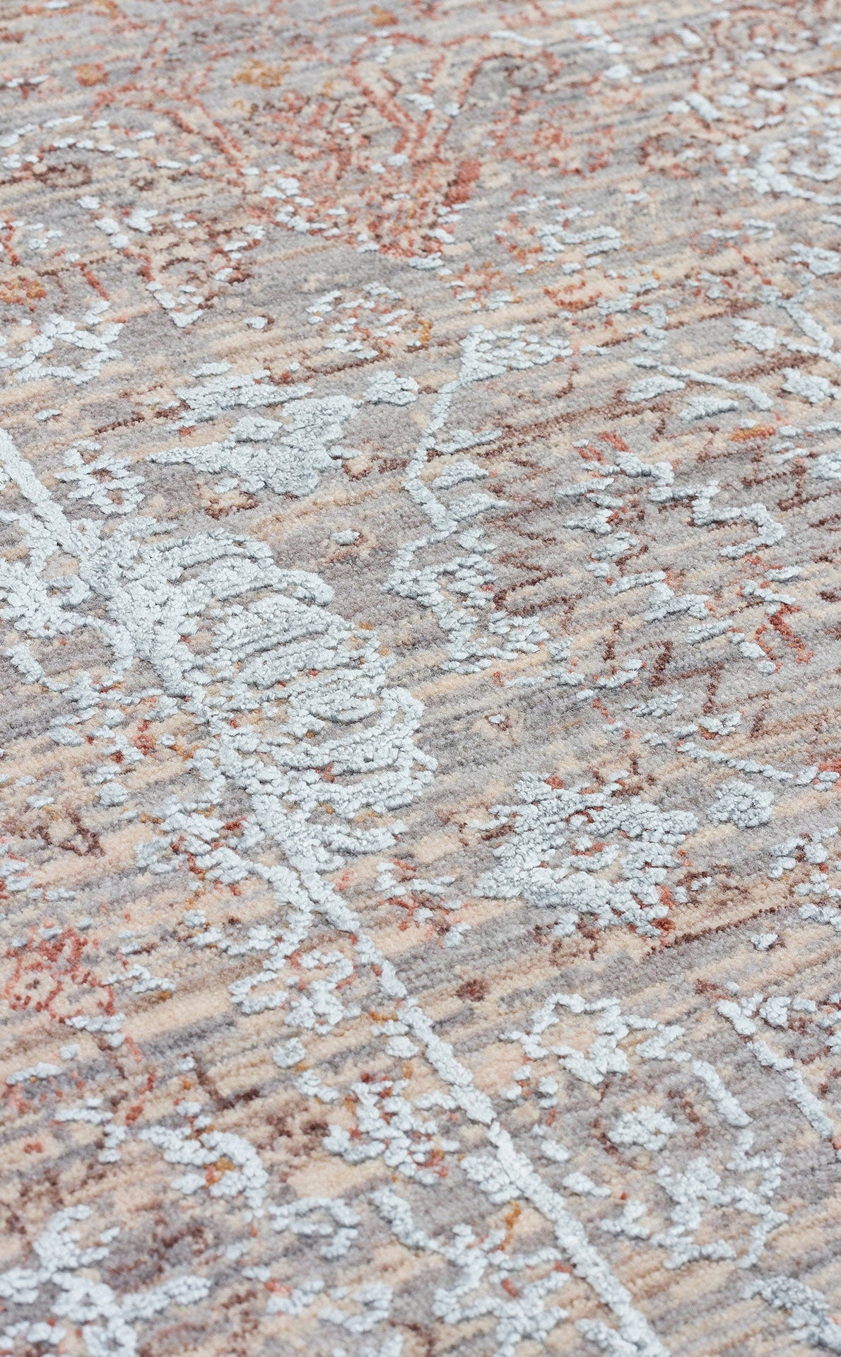 Distressed rug with a raised light blue floral pattern over a textured beige, grey, and rust-colored base.