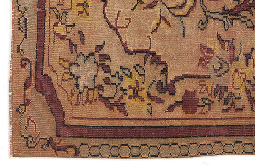 Load image 1 in gallery view. Tan rug with a dark red border and stylized floral motifs in yellow, brown, and grey.