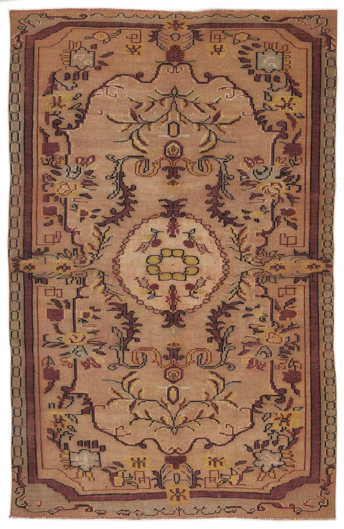 Tan and rust-colored traditional rug with a central floral medallion and geometric border on a white background.