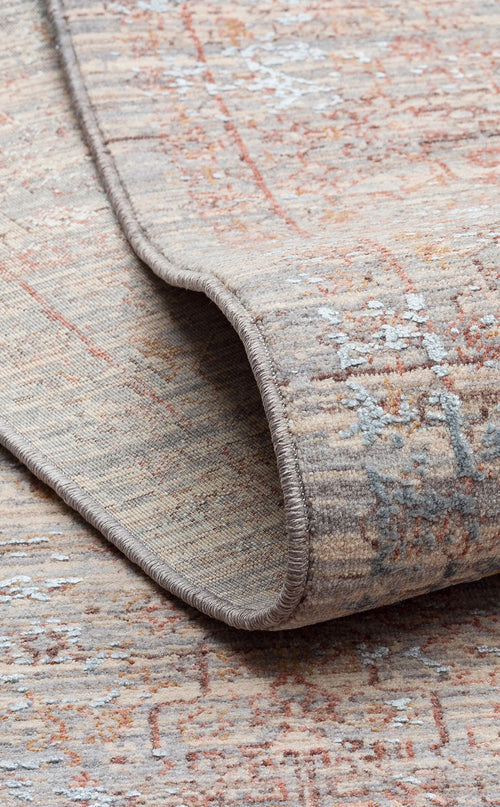 Load image 1 in gallery view. Beige and grey distressed rug with a faded traditional pattern and rust-colored accents, shown with a folded corner.