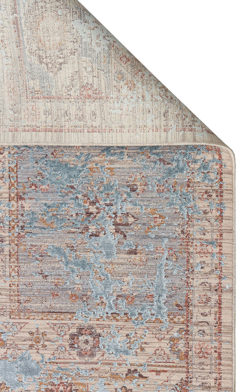 Load image 1 in gallery view. Beige and blue distressed traditional rug with a faded medallion pattern, shown with a corner folded over.