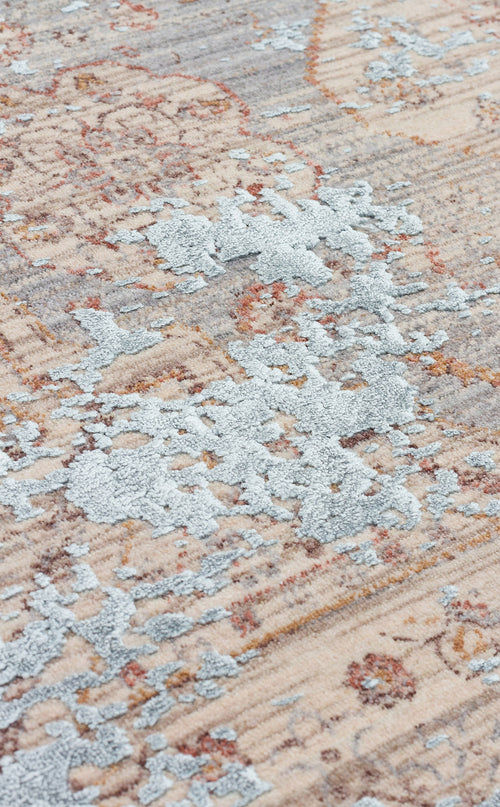 Load image 1 in gallery view. Beige and grey distressed rug with a raised, textured blue floral medallion pattern.